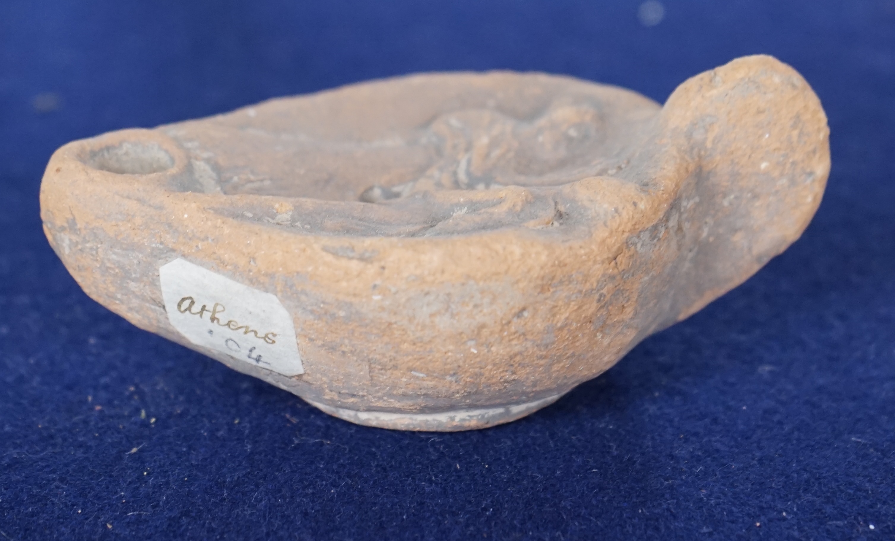 An Ancient Greek 'Athens' terracotta oil lamp, 10cm. Condition - fair